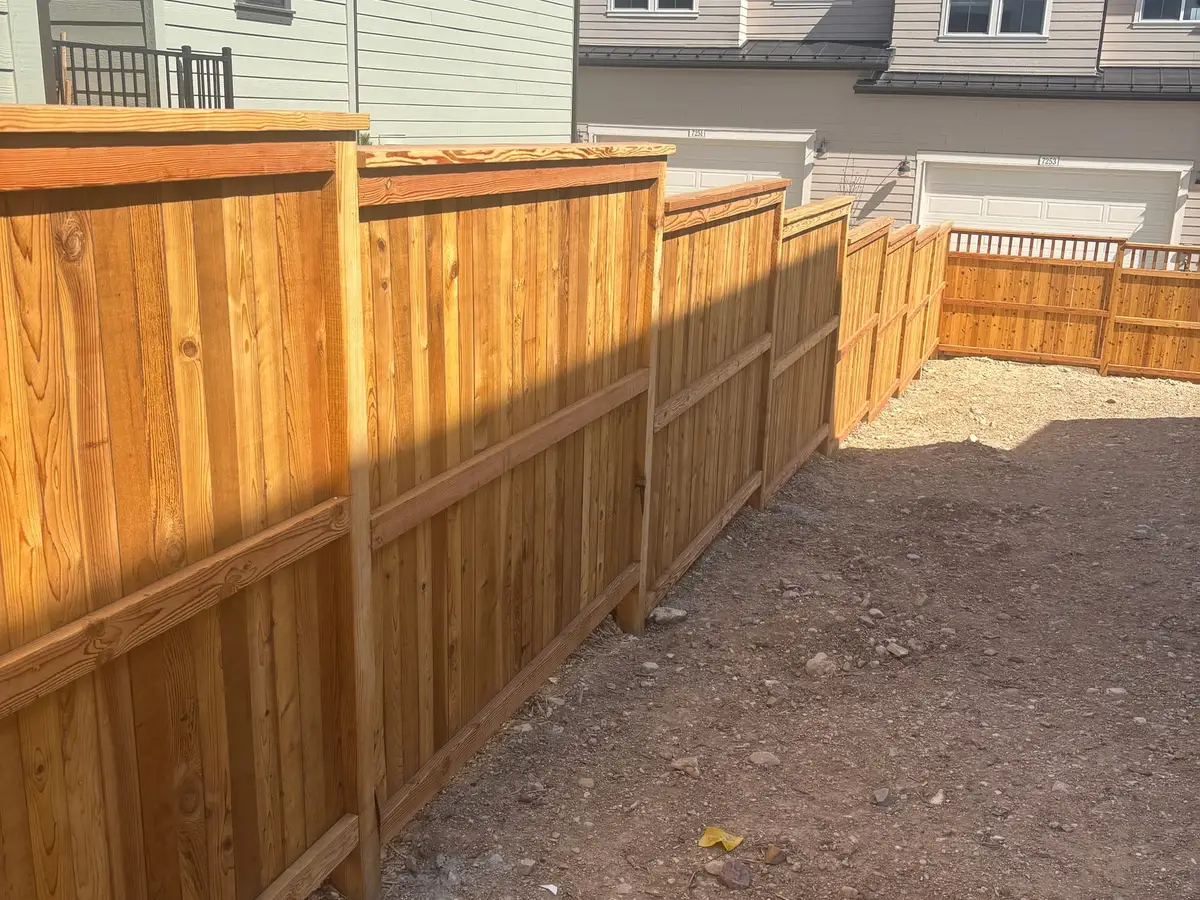 Cedar privacy fence with a top rail along a side yard