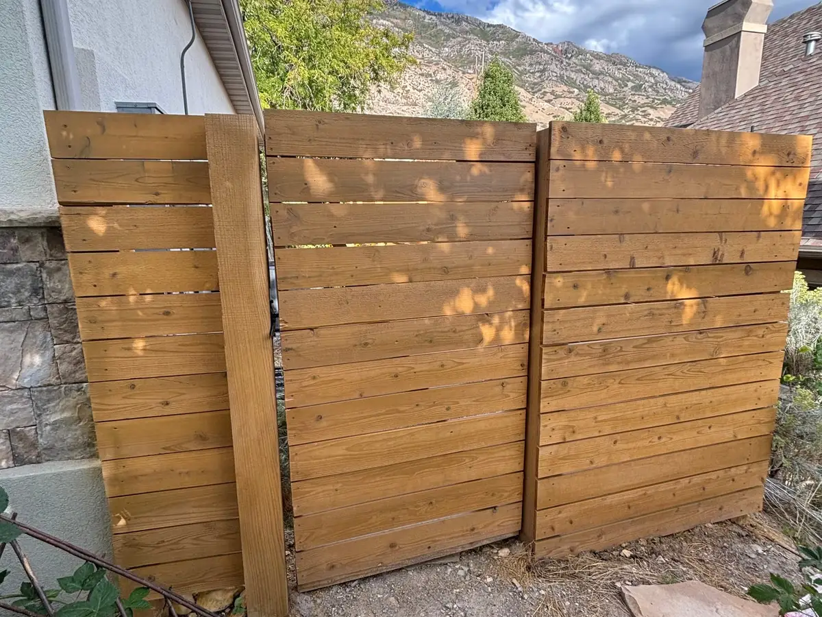 Horizontal cedar fence meeting a stone wall